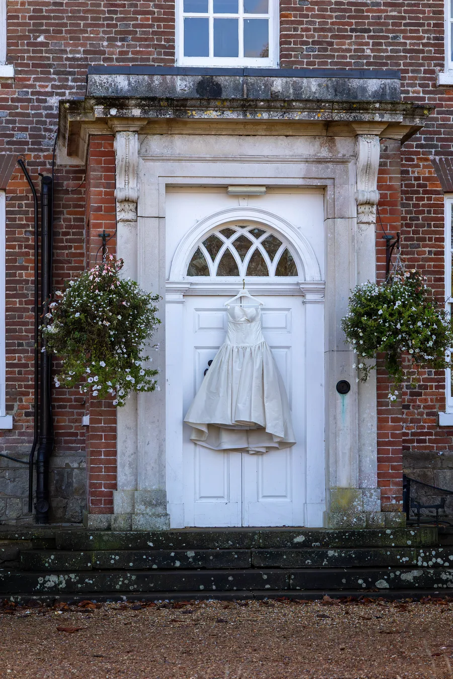 A wedding dress hanging in the doorway of a Georgian country house