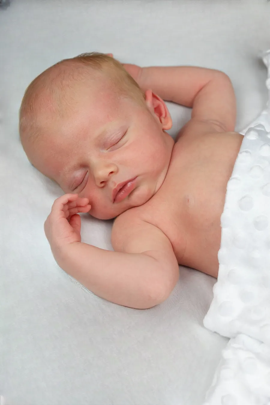 Newborn asleep with one arm above their head