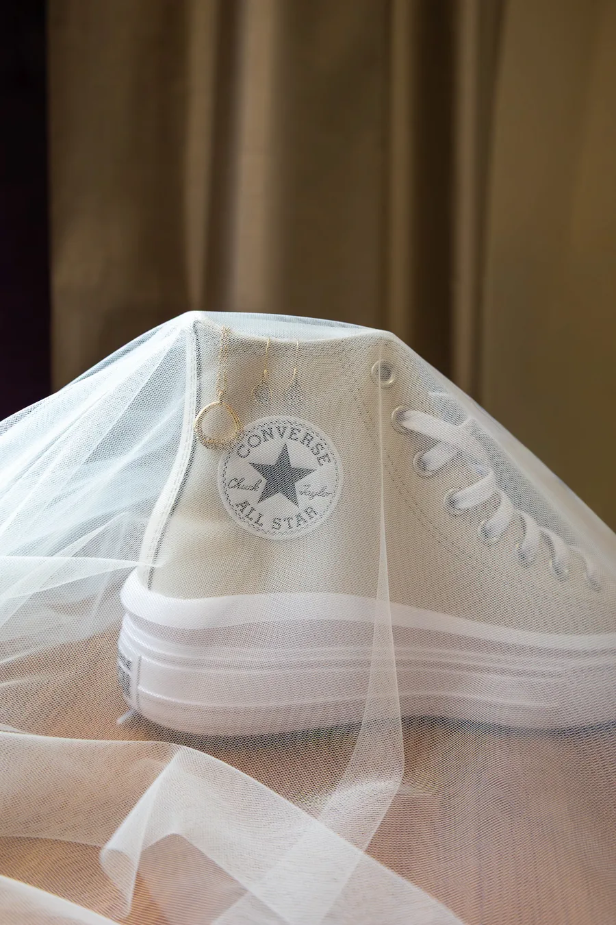 Bridal Converse trainers resting on the veil