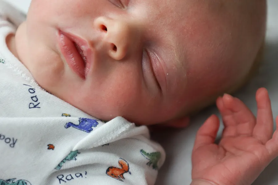 Close-up of a newborn's face and open hand