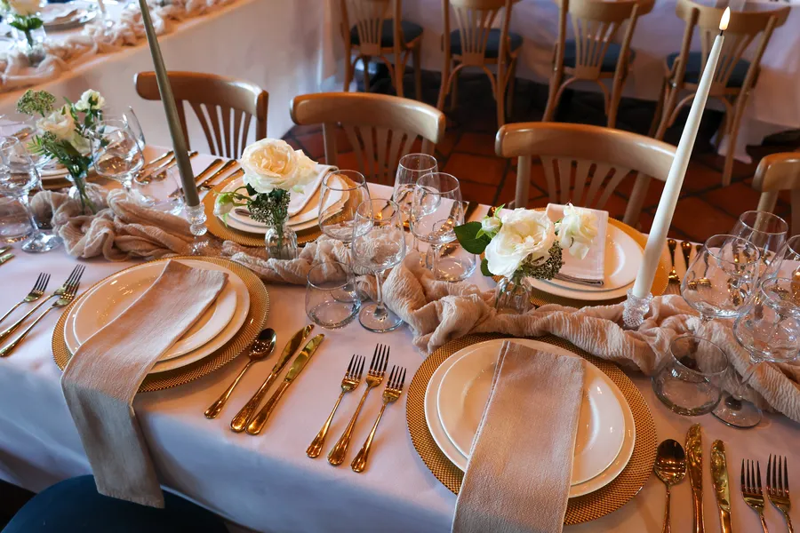 Place setting with gold charger plates, linen napkin and fresh flowers