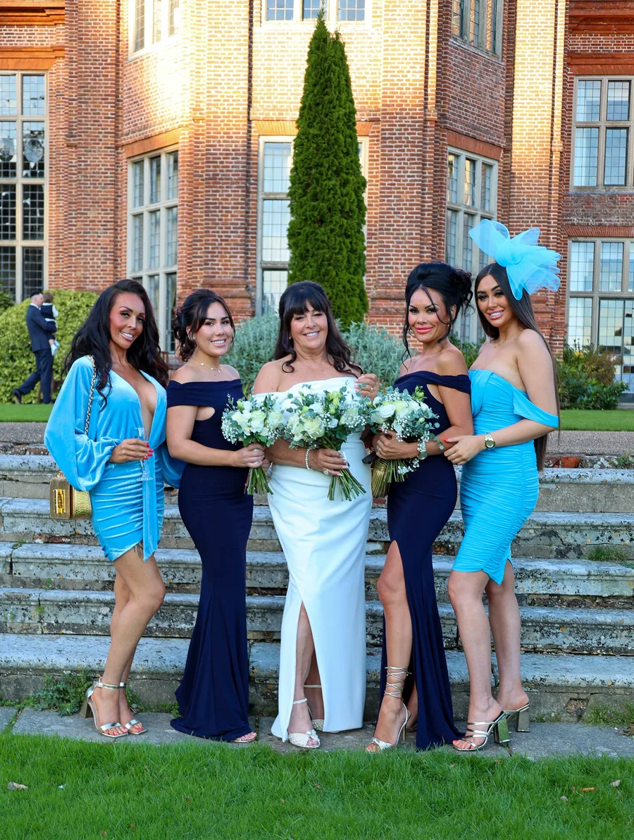 Bride with her bridesmaids in blue and navy on the steps of the venue