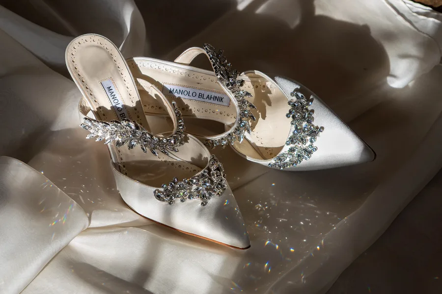 Crystal-embellished bridal shoes on ivory silk
