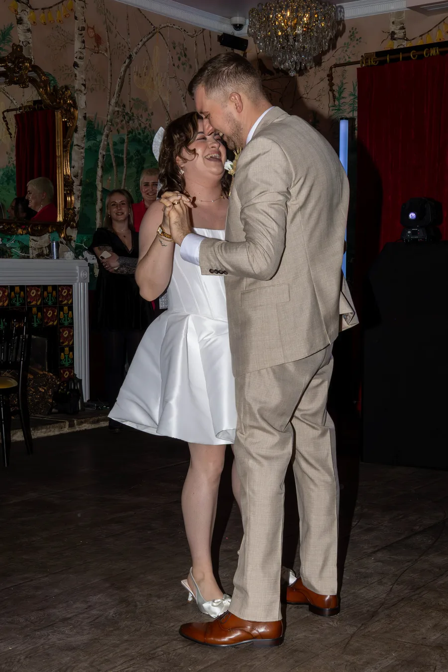 Bride and groom sharing their first dance in a candlelit reception room