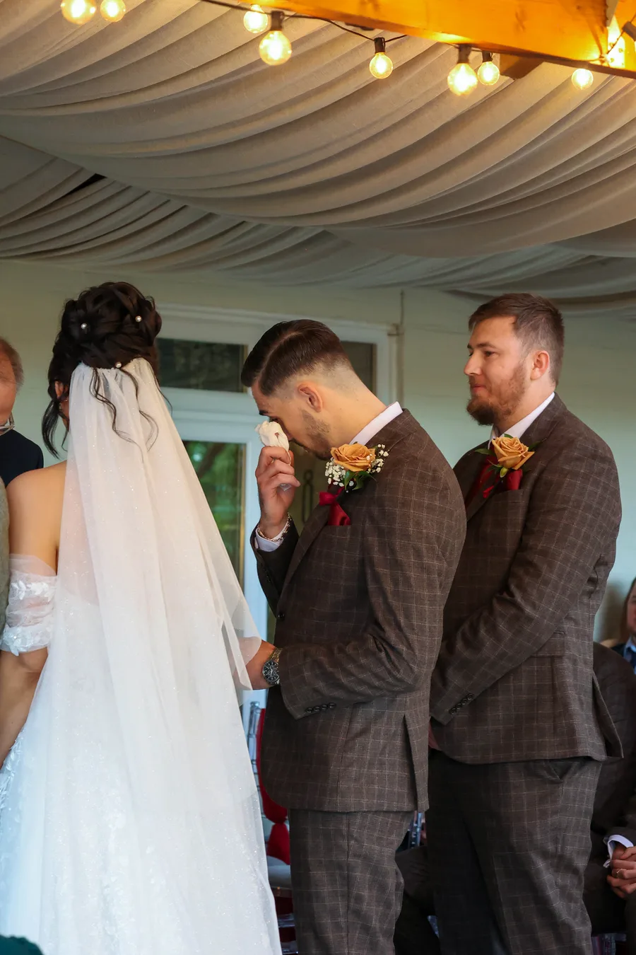 Groomsmen wiping away tears during the ceremony