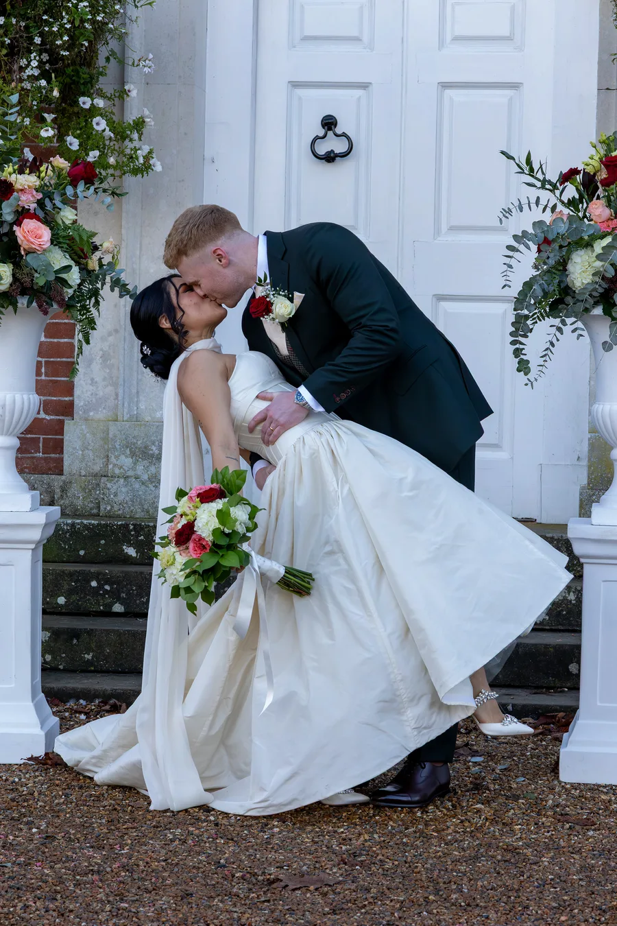 Groom dipping the bride for a kiss by the front door