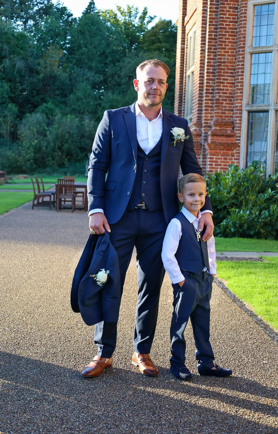 Groom walking up the drive with his page boy