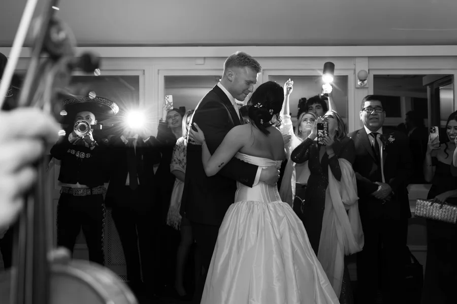 First dance surrounded by guests, in black and white