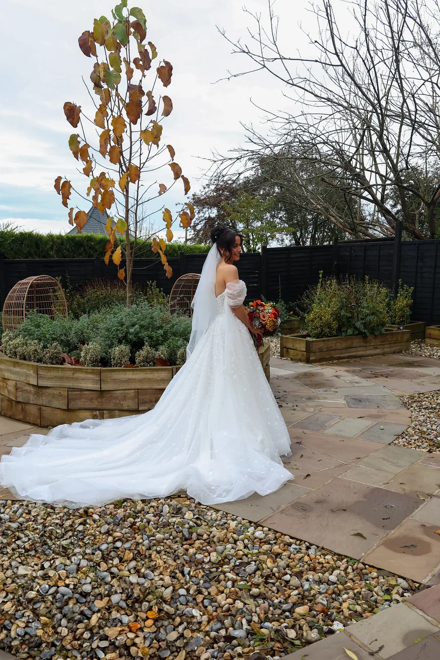 Bride from behind with her train spread across the garden