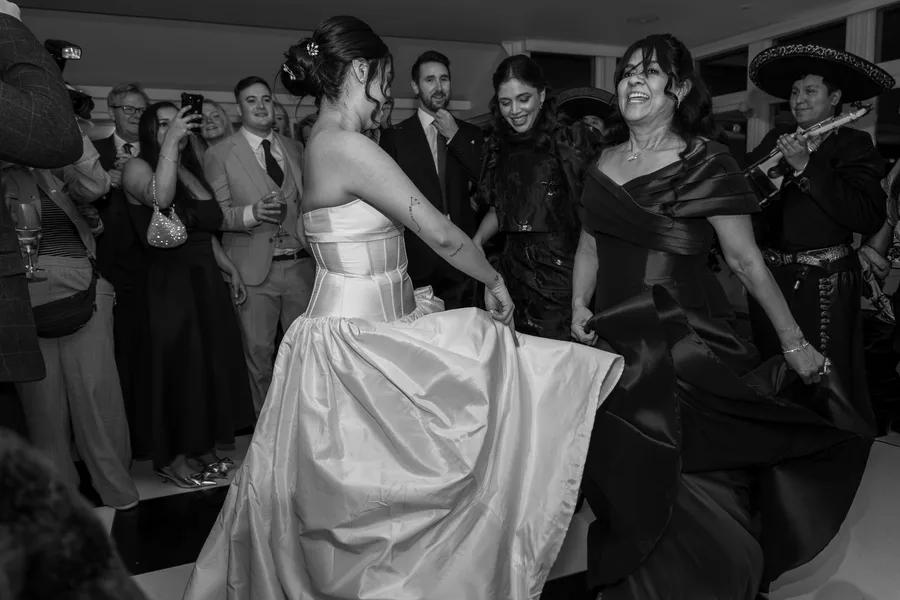 Bride dancing with her guests, in black and white