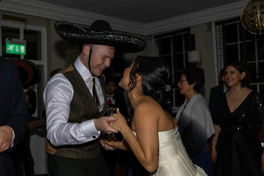 Guests dancing in sombreros at the evening party