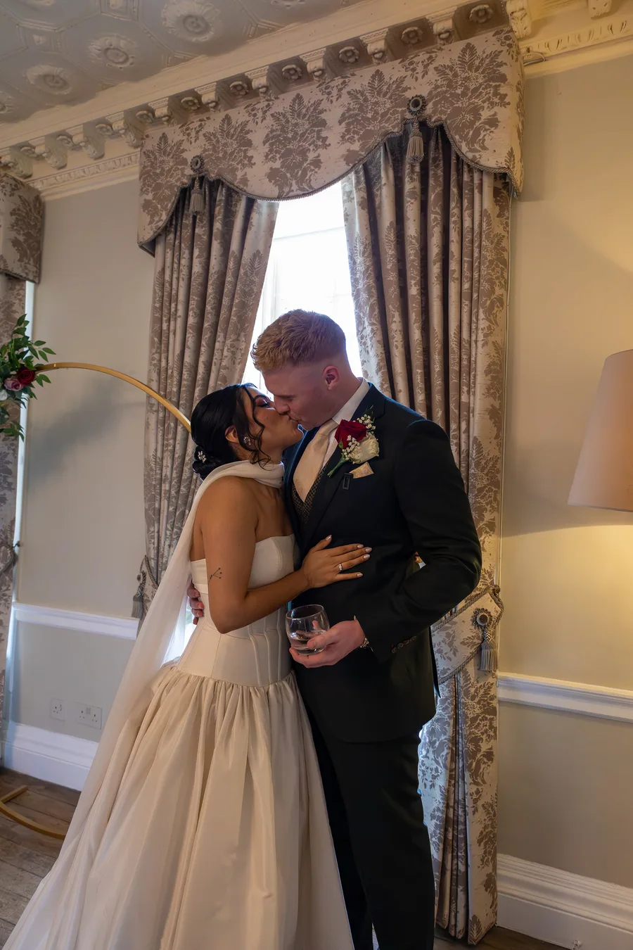 Bride and groom kissing in a bay window