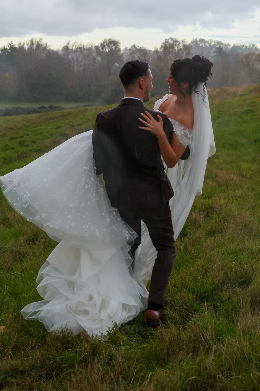 Groom lifting the bride in a misty field