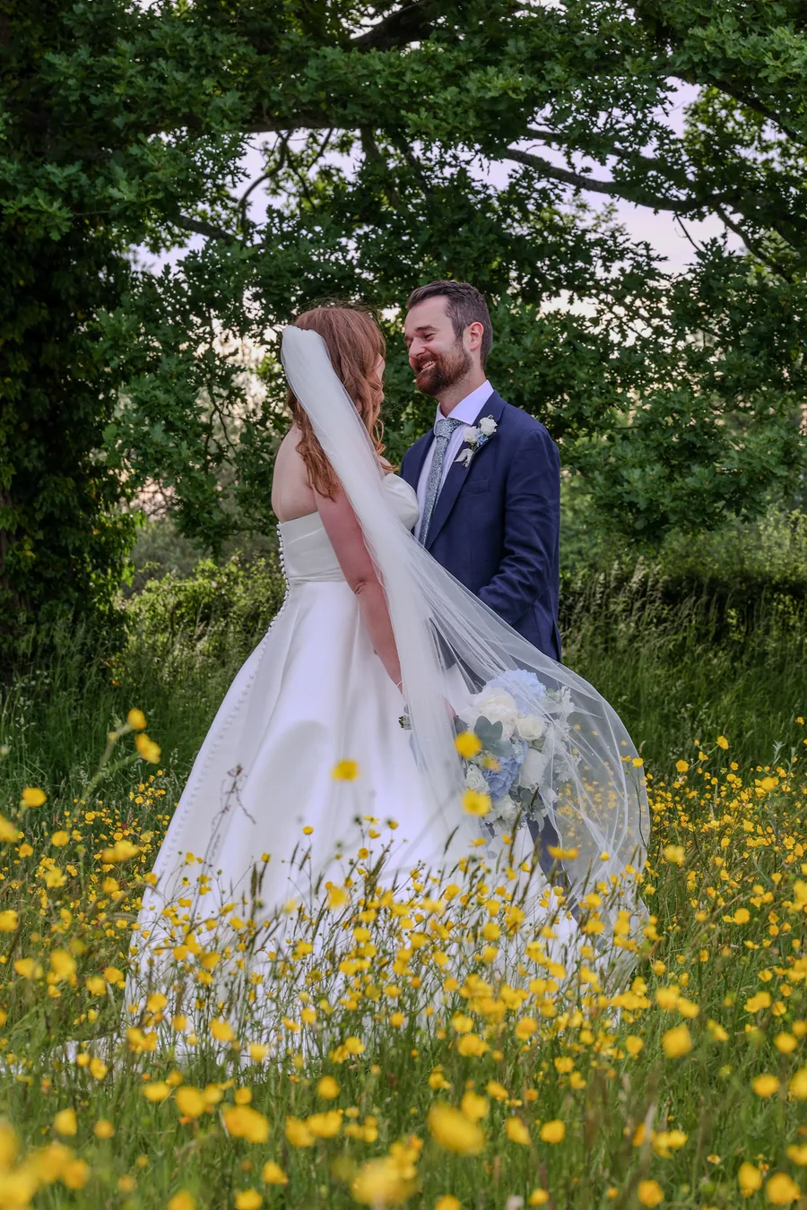 The bride's veil catching the light in a buttercup meadow